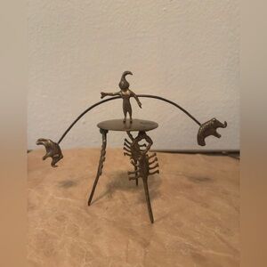 Brass balancing sculpture over scorpions